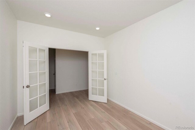 empty room featuring light hardwood / wood-style flooring and french doors