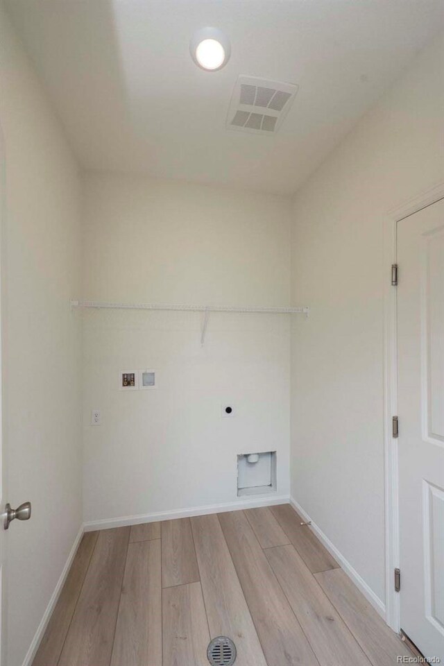 washroom featuring light wood-type flooring, hookup for a washing machine, and electric dryer hookup