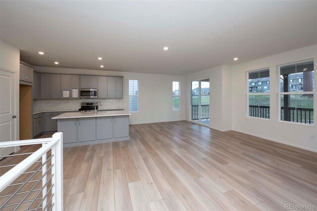 kitchen with appliances with stainless steel finishes, gray cabinets, and a wealth of natural light