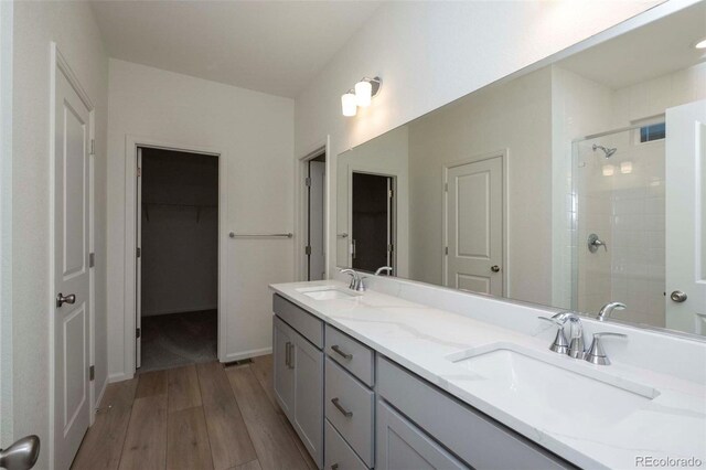 bathroom featuring wood-type flooring, vanity, and an enclosed shower