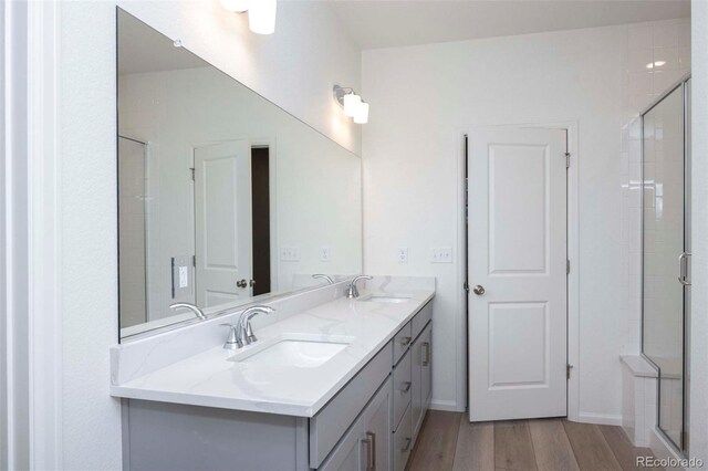 bathroom featuring a shower with door, vanity, and hardwood / wood-style flooring