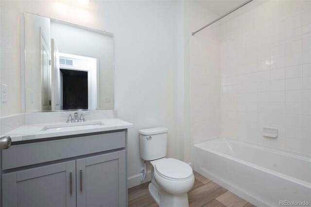 full bathroom with  shower combination, vanity, toilet, and hardwood / wood-style flooring