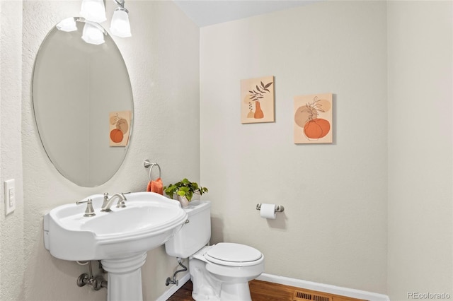 bathroom with hardwood / wood-style floors and toilet