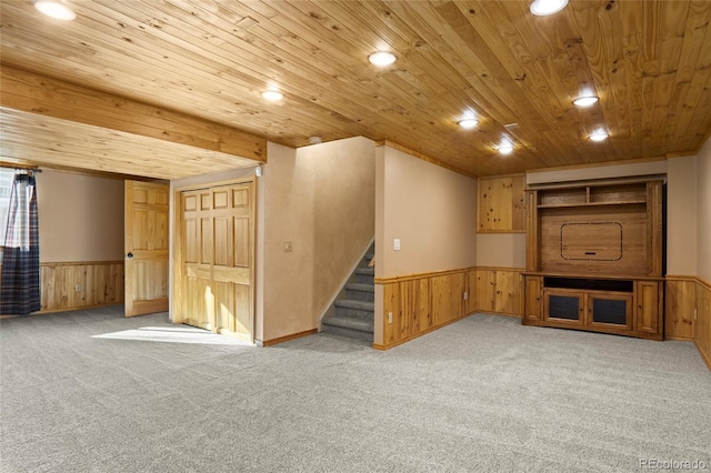 unfurnished living room featuring light carpet, wooden ceiling, and wood walls