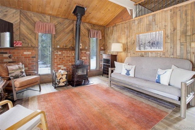 living room featuring a wood stove, wooden walls, and light hardwood / wood-style flooring