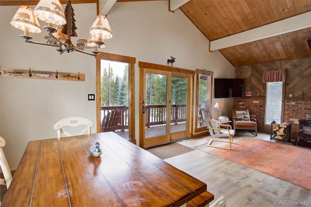 dining room with beam ceiling, light wood-type flooring, high vaulted ceiling, and an inviting chandelier