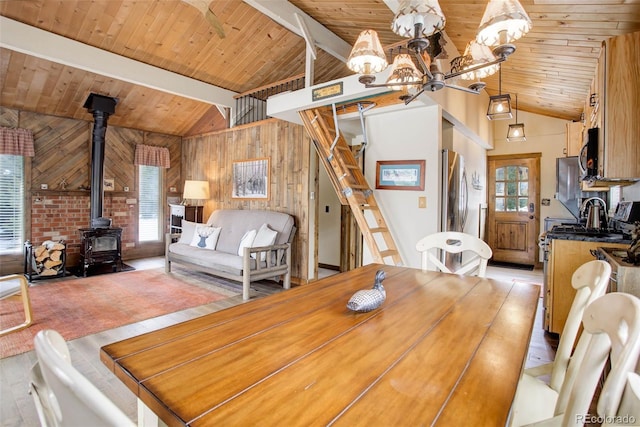 unfurnished dining area featuring light hardwood / wood-style flooring, a wood stove, plenty of natural light, and a notable chandelier