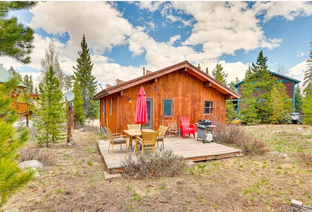 rear view of property featuring a wooden deck