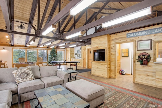 living room featuring beamed ceiling, hardwood / wood-style flooring, wooden walls, and wood ceiling