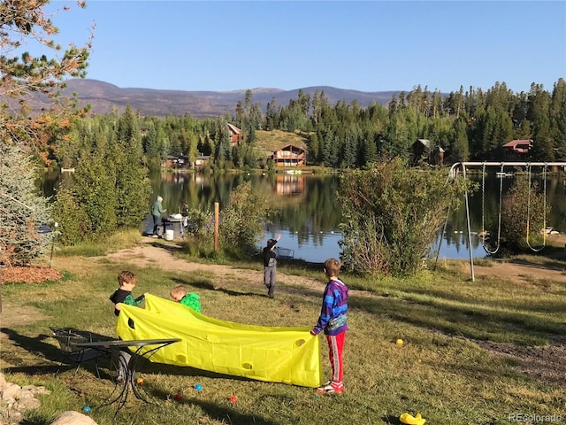 view of home's community featuring a yard and a water and mountain view