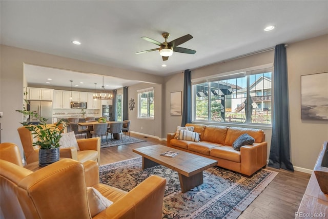 living area featuring baseboards, a ceiling fan, recessed lighting, and wood finished floors