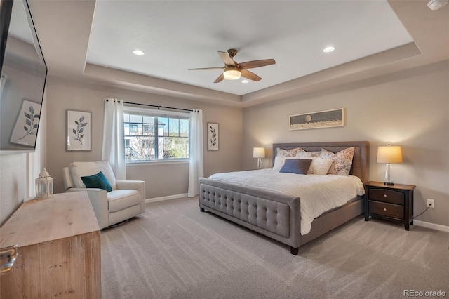bedroom with a tray ceiling, baseboards, carpet flooring, recessed lighting, and ceiling fan