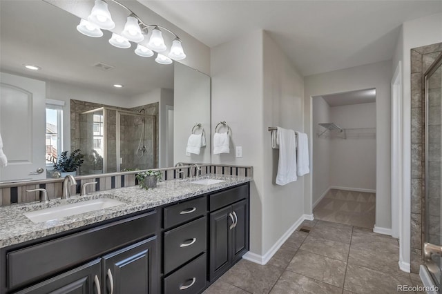 bathroom featuring a shower stall, a spacious closet, tile patterned floors, and double vanity