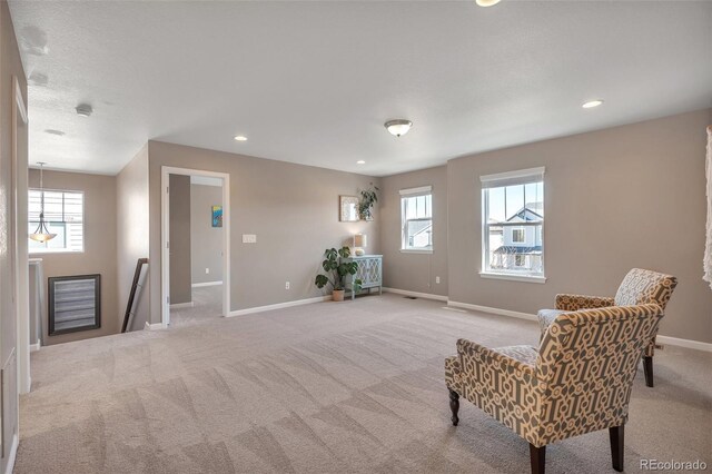 sitting room featuring light carpet, healthy amount of natural light, baseboards, and recessed lighting
