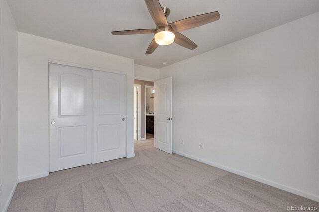 unfurnished bedroom featuring baseboards, light carpet, a closet, and a ceiling fan