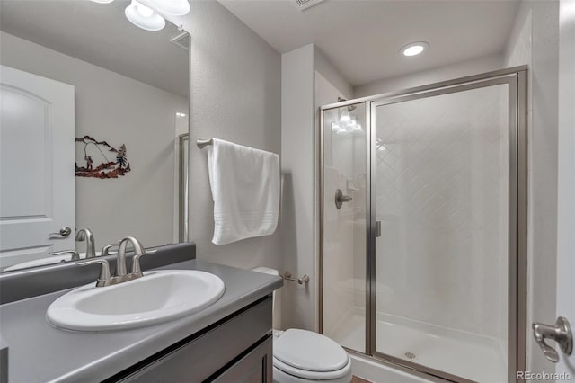 full bathroom with a shower stall, vanity, and toilet