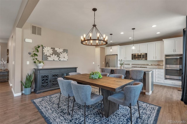 7665 Grady Cir, Castle Rock, CO 80108 - dining room with light wood-style floors, a chandelier, baseboards, and recessed lighting