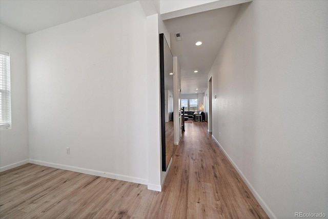 corridor featuring baseboards, recessed lighting, and light wood-style flooring