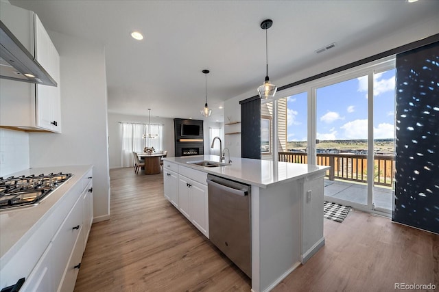 kitchen featuring visible vents, light wood-type flooring, white cabinets, a sink, and stainless steel appliances