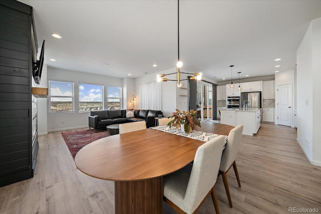 dining space with baseboards, recessed lighting, and light wood-type flooring
