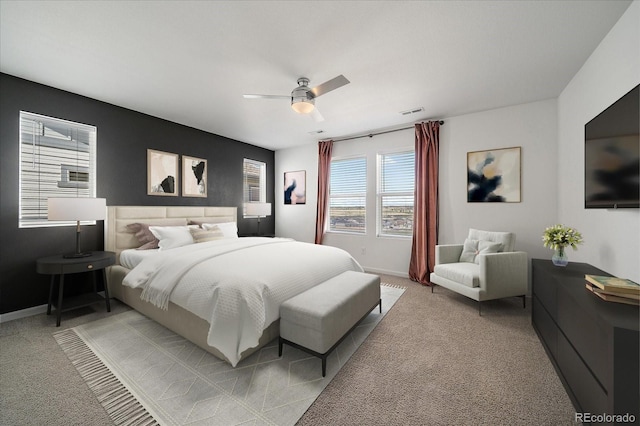 bedroom with baseboards, visible vents, a ceiling fan, and light colored carpet