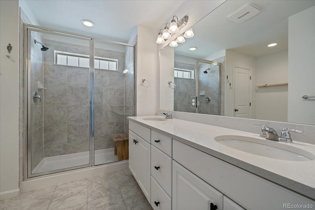 full bathroom with double vanity, a sink, recessed lighting, and a shower stall