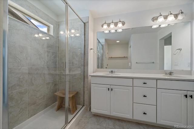 bathroom featuring double vanity, a shower stall, and a sink
