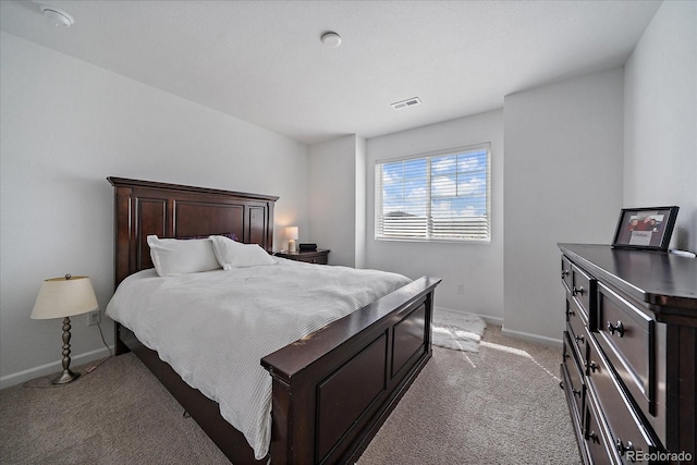 bedroom with visible vents, baseboards, and light carpet