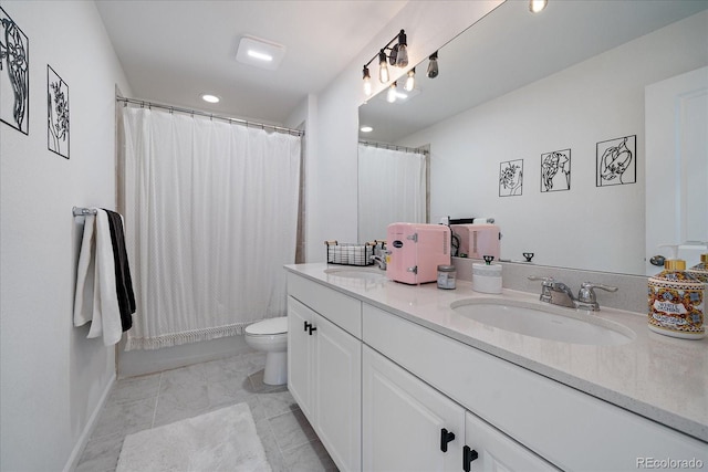 bathroom with double vanity, a sink, curtained shower, and toilet