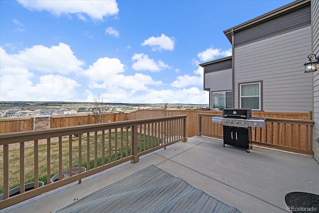 wooden terrace featuring a lawn, fence, and grilling area