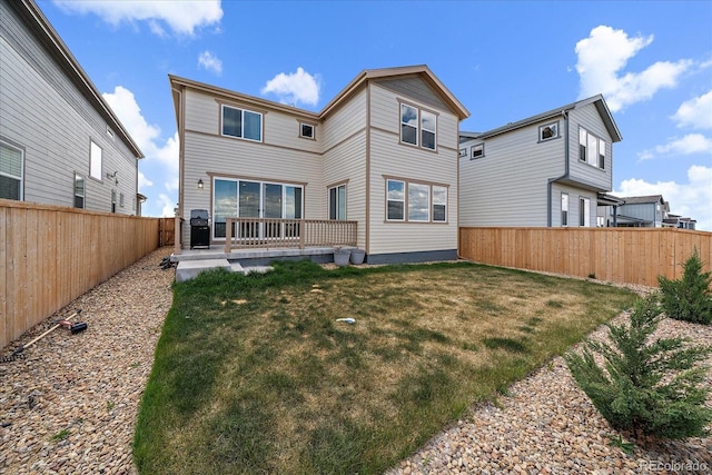 rear view of property with a fenced backyard and a yard