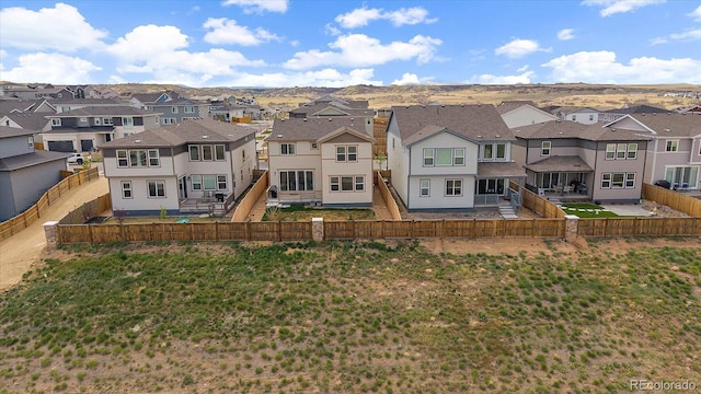 rear view of house featuring a fenced backyard and a residential view