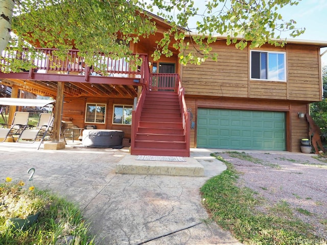 view of front facade featuring a garage, a deck, and a patio