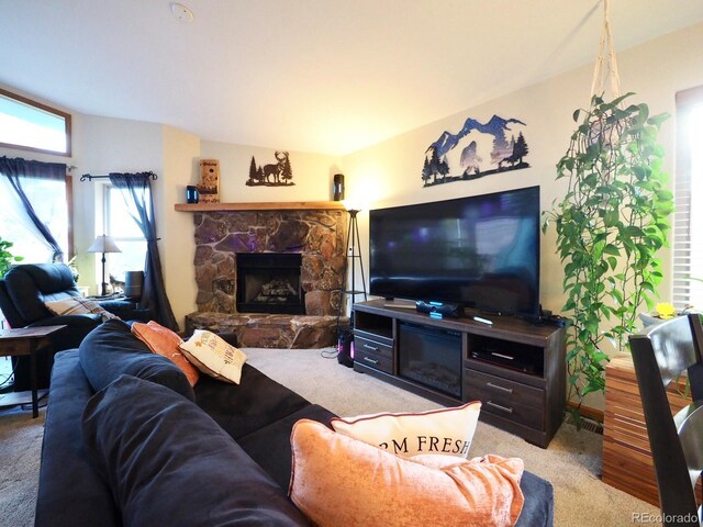 living room featuring carpet floors and a stone fireplace