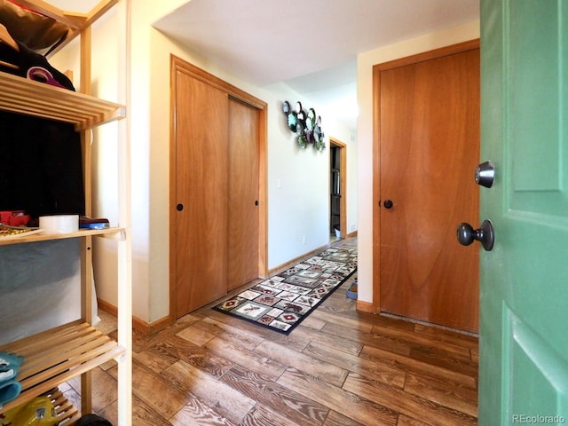 hall featuring baseboards and wood finished floors