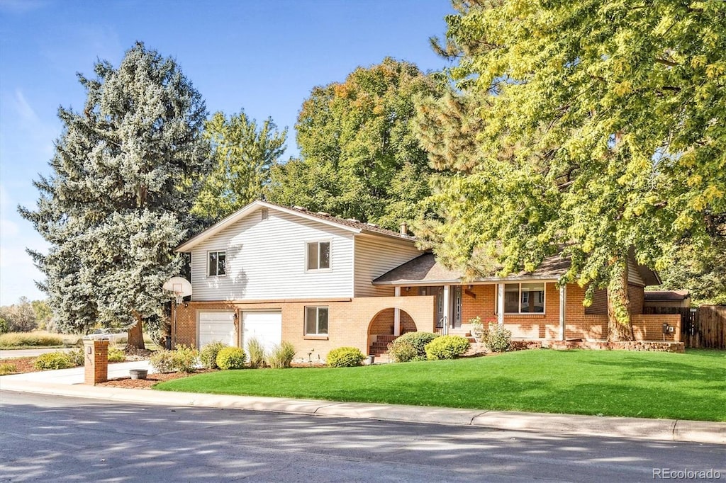 split level home featuring a front lawn and a garage