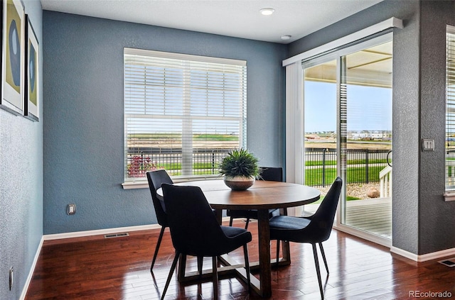 7426 E 148th Pl, Thornton, CO 80602 - dining space featuring a textured wall, hardwood / wood-style flooring, and baseboards
