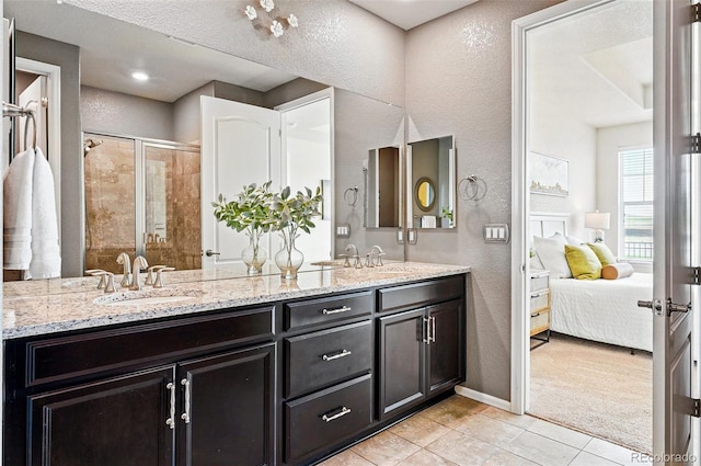 7426 E 148th Pl, Thornton, CO 80602 - bathroom featuring a textured wall, tile patterned flooring, a stall shower, double vanity, and ensuite bathroom