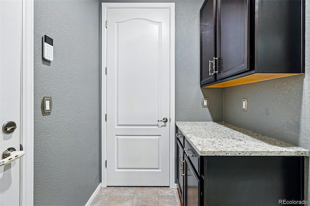 7426 E 148th Pl, Thornton, CO 80602 - laundry area featuring a textured wall, baseboards, and light tile patterned flooring