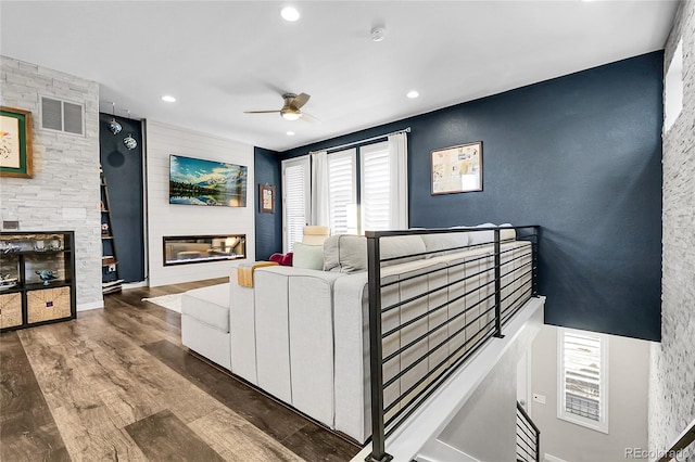 living area with visible vents, wood finished floors, a fireplace, recessed lighting, and a ceiling fan