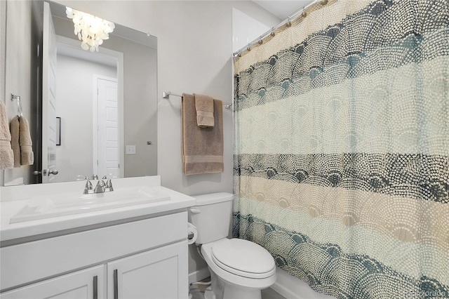 full bathroom with vanity, curtained shower, toilet, and an inviting chandelier