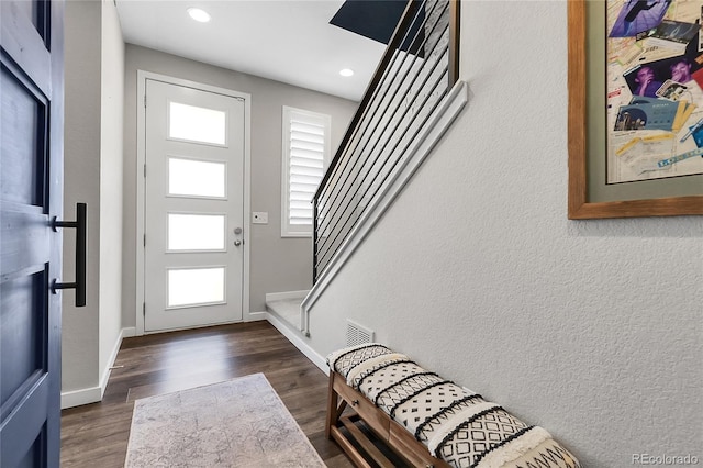 foyer featuring a healthy amount of sunlight, stairway, and dark wood-type flooring