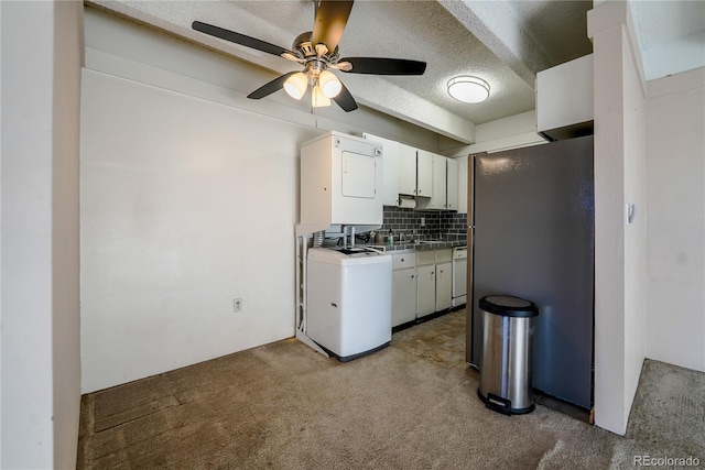 kitchen featuring decorative backsplash, stacked washer and dryer, white cabinets, and ceiling fan