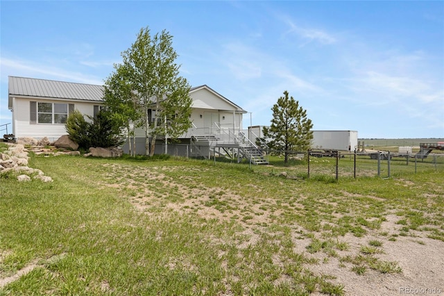 view of yard with fence and stairway