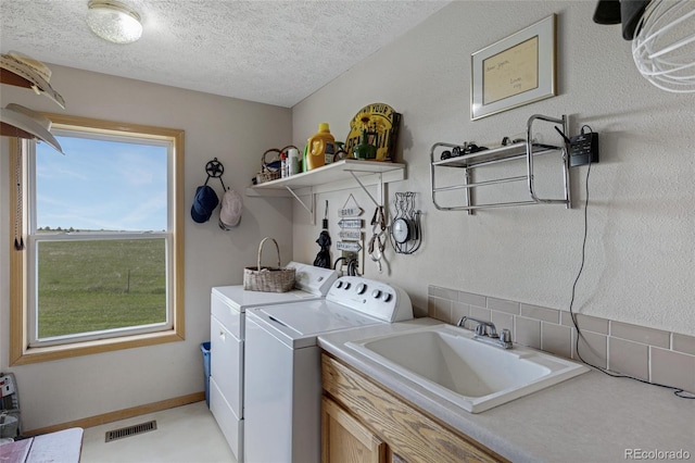 washroom with washing machine and clothes dryer and a textured ceiling
