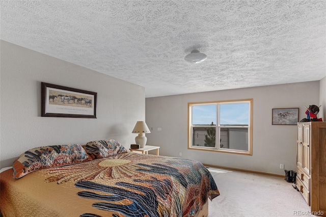 bedroom featuring carpet floors, baseboards, and a textured ceiling