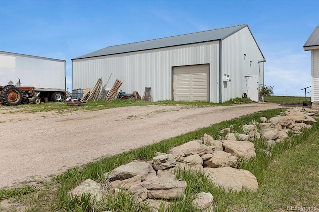 view of outbuilding with driveway and an outbuilding