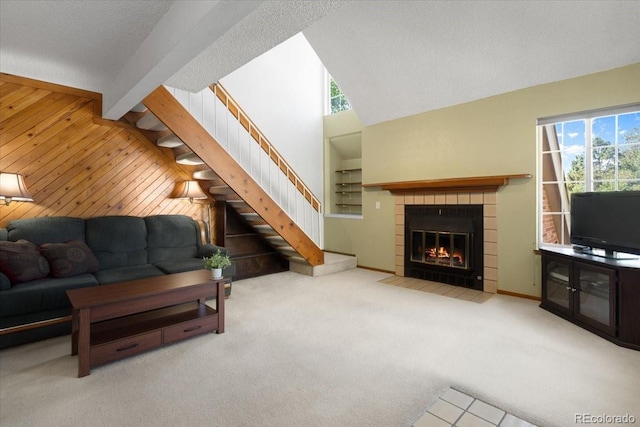 13873 E Lehigh Ave Unit E, Aurora, CO 80014 - living area featuring stairs, wood walls, carpet floors, a tile fireplace, and built in features