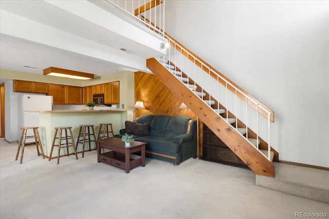 13873 E Lehigh Ave Unit E, Aurora, CO 80014 - living room with light carpet, stairs, and wooden walls