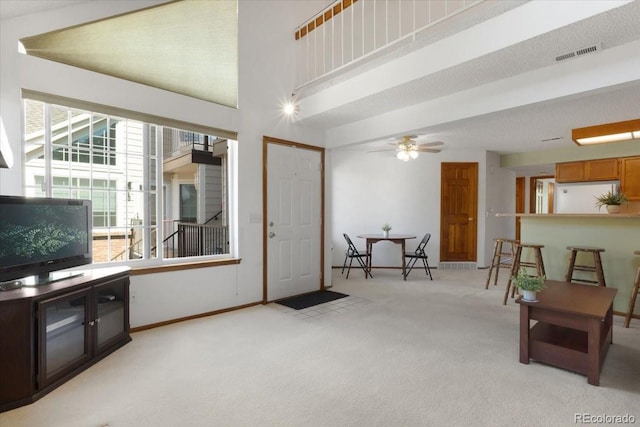 13873 E Lehigh Ave Unit E, Aurora, CO 80014 - living area with light colored carpet, a towering ceiling, and a ceiling fan